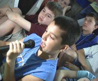 Image of some kids talking into a microphone.